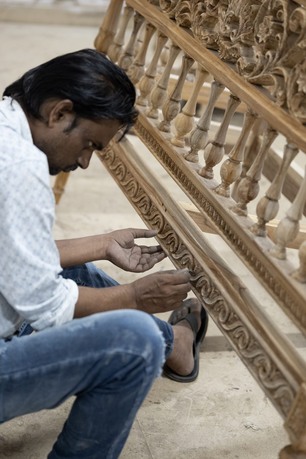 A craftsman carving the back of a settee by hand in the workshop